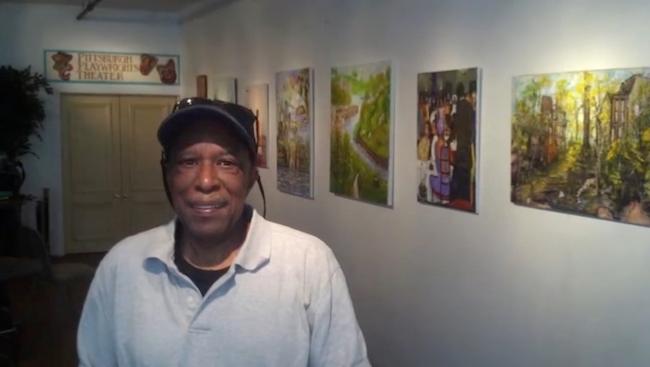 Ernest McCarty Jr. au milieu de ses toiles, image extraite de YouTube
